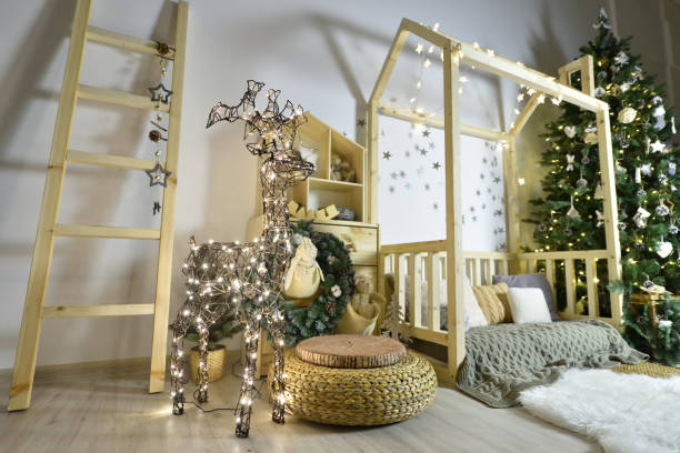 クリスマスツリー、おもちゃ、ギフト、花輪で作られた輝く鹿で新年の休日のために飾られた木製家具、家、階段を備えた美しい子供のプレイルーム - bedroom indoors wall bedding ストックフォトと画像