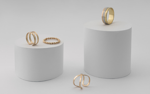 Golden rings collection on white platform