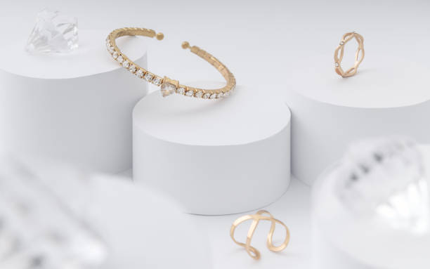 istock Golden bracelet and rings on white cylinders 1179856940