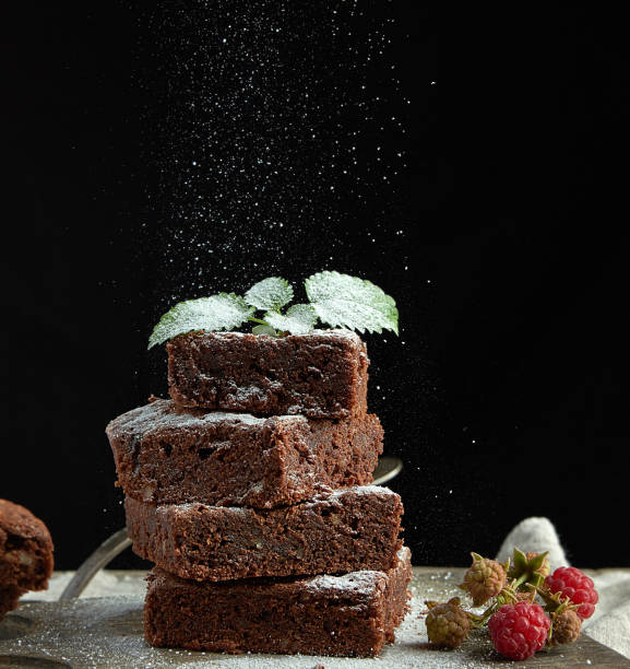 istock stack of square baked brownie chocolate cake slices sprinkled with white sugar 1179866088