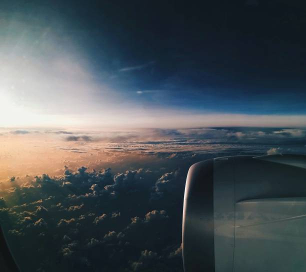 Clouds and sunset from plane window stock photo