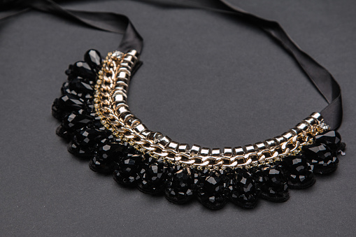 Necklace with black stones on gray background