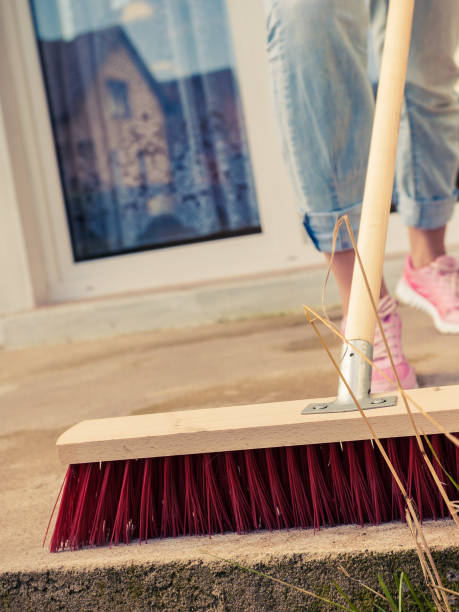 istock Person cleaning patio using brush broom 1179878007