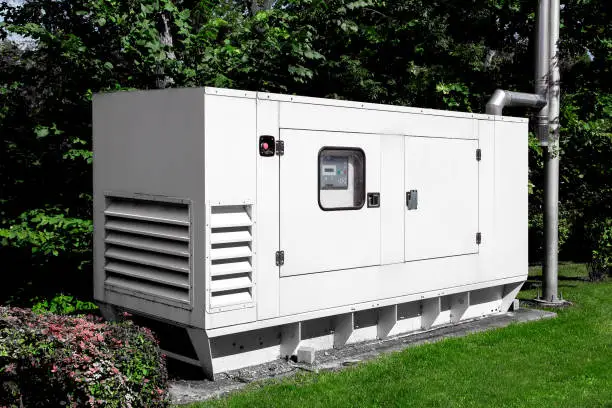 Photo of emergency generator for uninterruptible power supply, diesel installation in an iron casing with an electric switchboard power management.