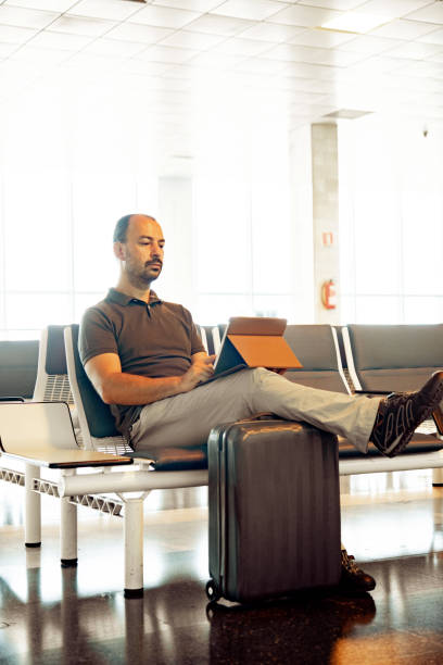 istock Adult Man Relaxing on Airport Terminal and Using Digital Tablet 1179881343