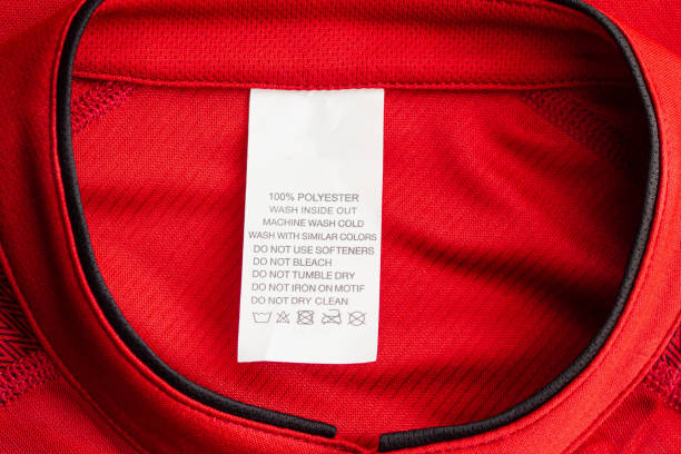 white laundry care washing instructions clothes label on red jersey polyester sport shirt - scale industry copy space special imagens e fotografias de stock