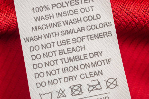 White laundry care washing instructions clothes label on red jersey polyester sport shirt