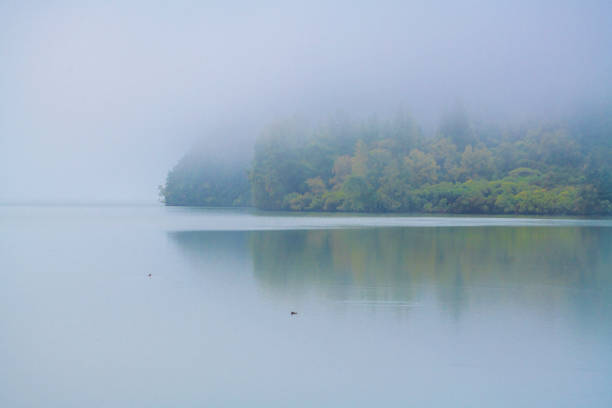istock Autumn color shows through heavy fog on glacial lake 1179887708