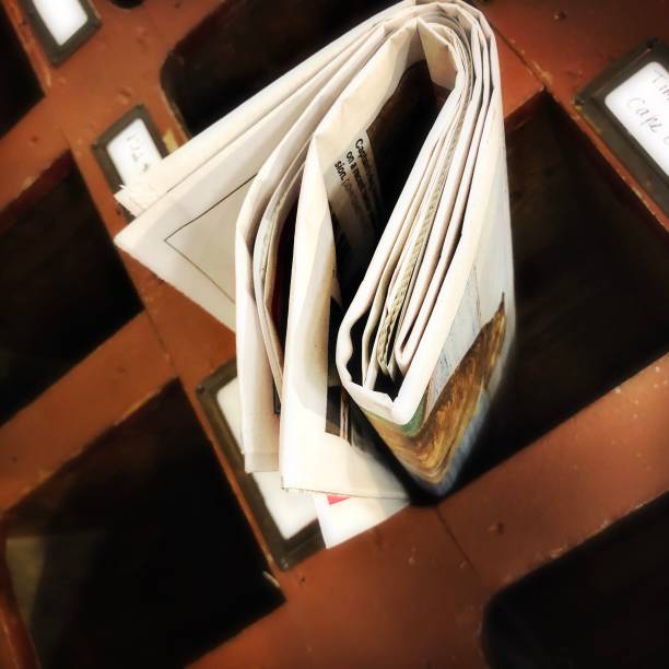 istock Newspaper Sticking out of a Mail Slot 1179890720