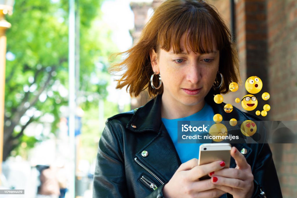 Woman using smartphone sending emojis. Close-up of woman using smartphone sending emojis. Social concept. Adult Stock Photo