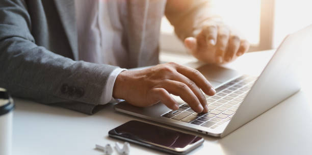 istock Close-up view of young businessman working on his project while typing on laptop computer 1179905420