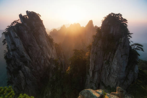 Sunrise at Yellow Mountain Sunrise over prominent pinnacles of HuangShan (Yellow Mountain) in Anhui Province, China. huangshan mountains stock pictures, royalty-free photos & images