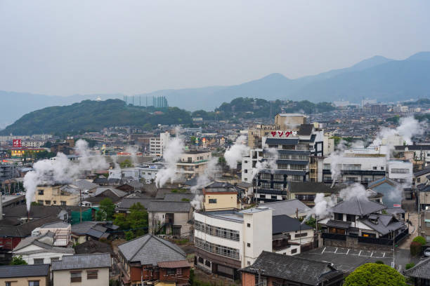 kyushu,beppu , japón ; mayo-1-2018 : el paisaje urbano de beppu brota de agua caliente en muchos lugares de la ciudad. aguas termales que aumentan el vapor en la vista superior de la ciudad con hermosa gama de montaña y cielo. - 12018 fotografías e imágenes de stock