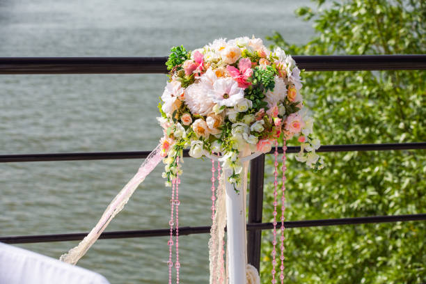 istock Decorative stands for decorating roses and peonies with ribbons developing in the wind on the banks of a river or ocean during a wedding ceremony. 1179923147