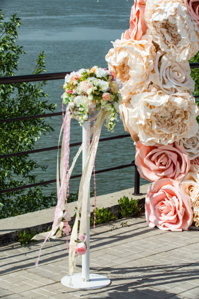 istock Decorative stands for decorating roses and peonies with ribbons developing in the wind on the banks of a river or ocean during a wedding ceremony. 1179923300