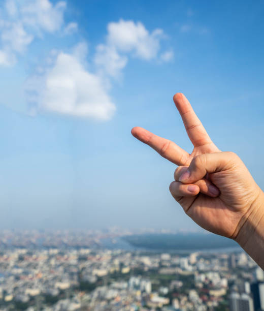 istock Two fingers raised on the city sky. 1179933264