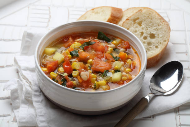 Seasonal vegetable soup with potatoes, carrots, onions, garlic, white beans, corn, tomatoes and parsley Seasonal vegetable soup with potatoes, carrots, onions, garlic, white beans, corn, tomatoes and parsley vegetable soup stock pictures, royalty-free photos & images