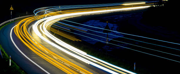 luces de coches con la noche. abstracción de senderos de luz - single line yellow road asphalt fotografías e imágenes de stock