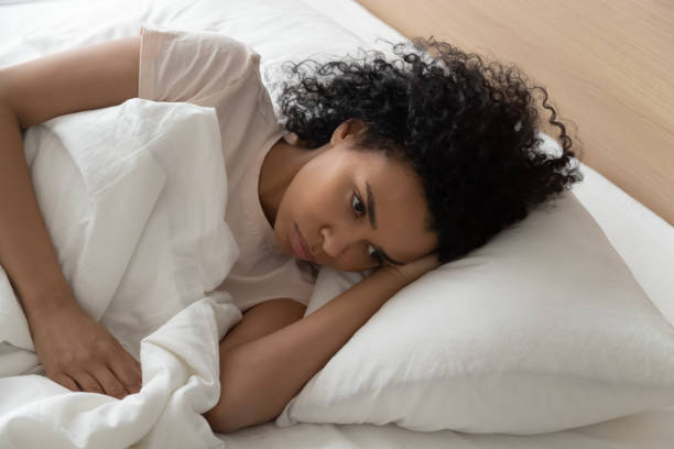 istock Black millennial woman lying in bed suffering from insomnia 1179938829