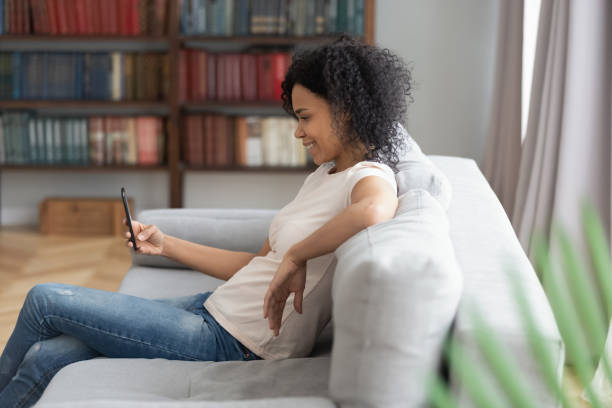 istock Smiling black young woman relax at home using cellphone 1179938835