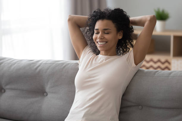 istock Smiling black woman relax on couch at home 1179938848