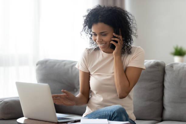 istock Smiling black woman multitask at home using gadgets 1179938867