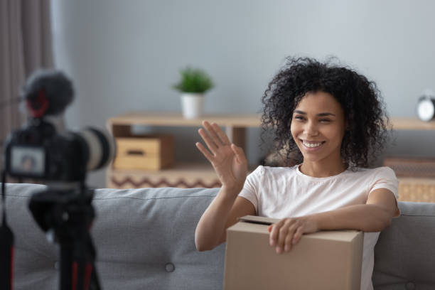 istock Smiling black girl vlogger shooting unpacking video on camera 1179938870