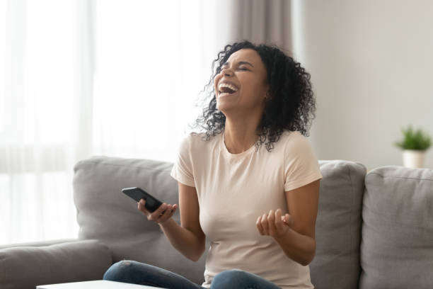 istock Overjoyed black woman laughing getting funny message on smartphone 1179938872