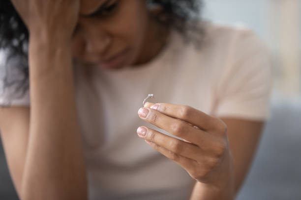 istock Depressed black woman hold wedding ring distressed with divorce 1179938889