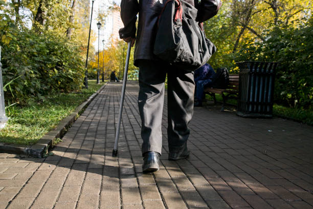 istock Old man walking down the street with walking stick 1179940480