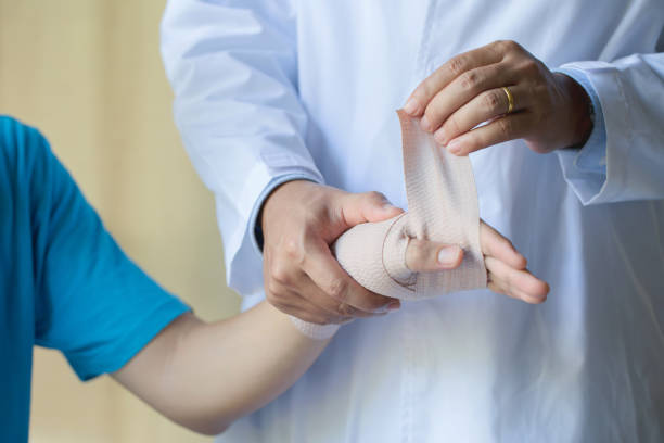 istock Orthopedist applying wrist elastic wrap on male patient hand joint dislocation 1179941617