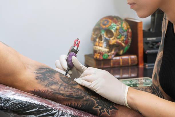 Details of a tattoo artist work Tattoo artist during tattooing a client on the forearm forearm tattoos men stock pictures, royalty-free photos & images