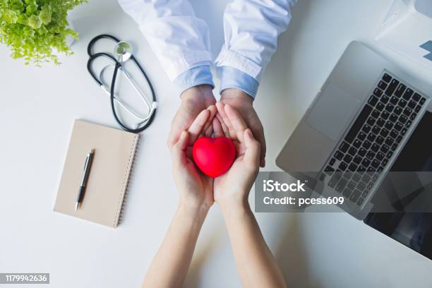 Top View Doctor And Patient Hands Holding Red Heart On White Table Health Care Love Give Hope And Family Concept World Heart Dayworld Health Day Stock Photo - Download Image Now