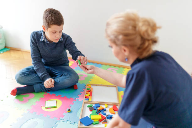 istock Female tutor assisting boy in motor skill class 1179942652