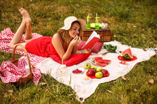 istock Woman eating fruit while reading a book outdoors 1179942678