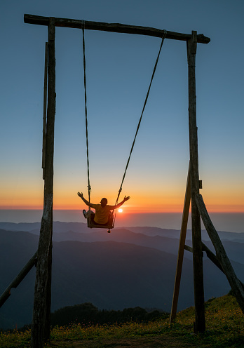 A man swinging with swing at the unrivaled sunset landscape of Huser Plateau