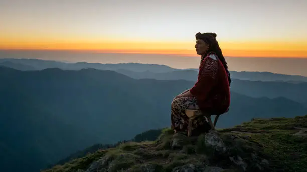 A black sea woman watching the sunset with traditional clothes