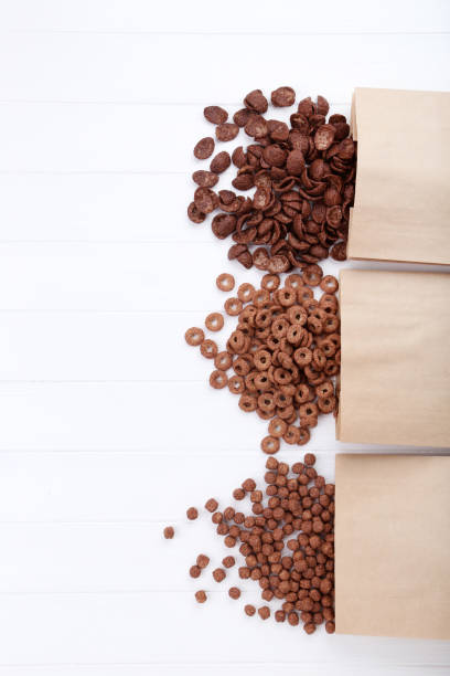 istock Various chocolate corn flakes with paper bags on white wooden table 1179942842