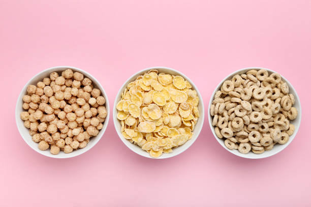 istock Various corn flakes in bowls on pink background 1179942905