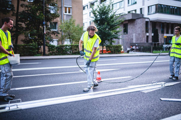 istock Skilled Road Crew Members Spray Painting Arrow Marking 1179947039