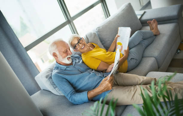 Mature couple reading magazines and having a conversation.