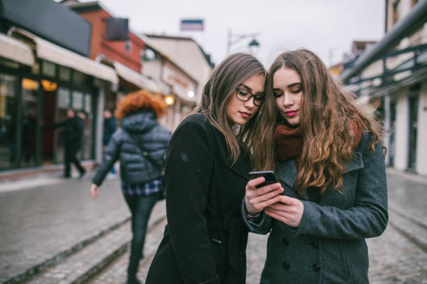 istock Two female friends using phone downtown 1179951872