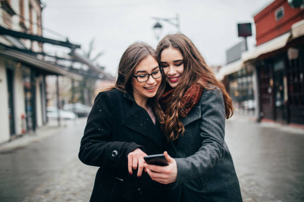 istock Two female friends using phone downtown 1179951923