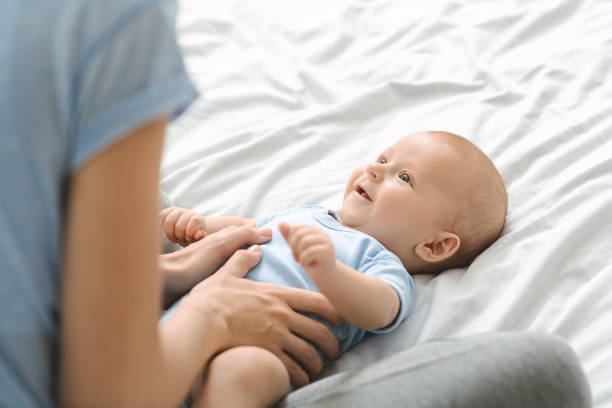 istock Caring mother gently massaging her newborn's son tummy 1179953302