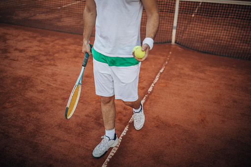 One man, handsome tennis player on tennis court, playing a match.