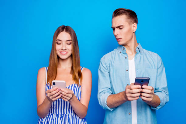 istock Portrait of his he her she two nice attractive lovely focused cheerful people using device spying on chatting messages isolated on bright vivid shine vibrant blue color background 1179953676
