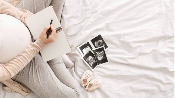 mujer embarazada señalando pensamientos en la cama - bolsa objeto fabricado fotos fotografías e imágenes de stock