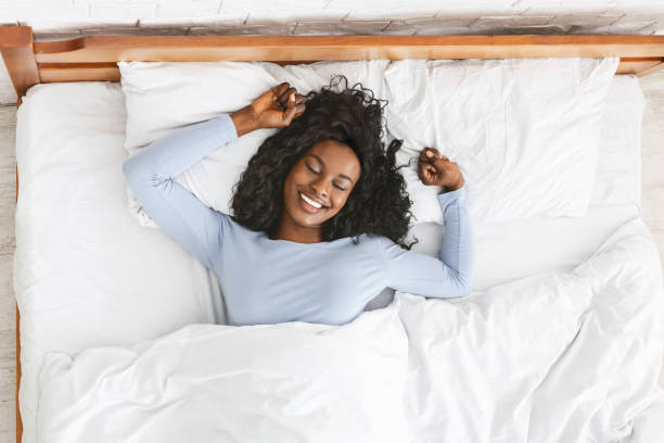 istock Top view of smiling woman stretching in bed 1179954652
