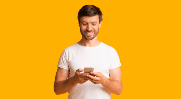 istock Happy Man Using Cellphone Over Yellow Background, Panorama 1179954960