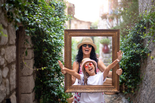 A cheerful mother and her daughter posing inside of a picture frame Vacation concept with family french riviera photos stock pictures, royalty-free photos & images